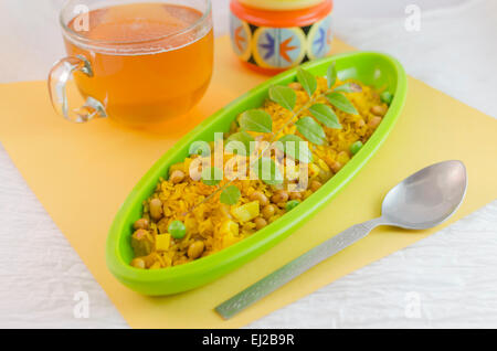 Poha est un snack indien populaire fait à partir de flocons de riz. Les flocons de riz sont légèrement frits dans l'huile avec de la moutarde,oignon,froid,curry l Banque D'Images