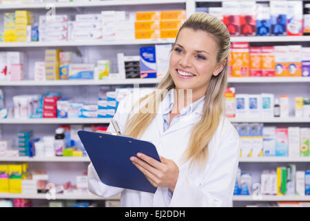 Stagiaire en pharmacie writing on clipboard Banque D'Images