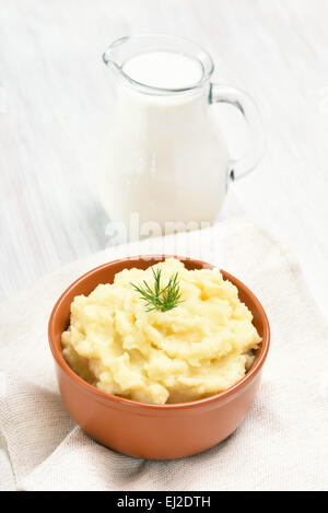 Purée de pommes de terre et pot de lait sur tableau blanc Banque D'Images