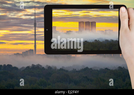 Travel Concept - office prend photo du lever du soleil et brouillard matin jaune en automne ville sur smartphone, Moscou Banque D'Images