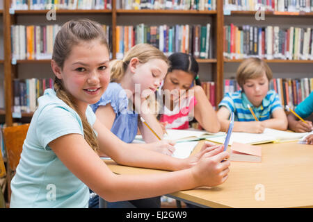 Cute élève using tablet computer in library Banque D'Images