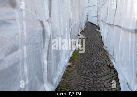 Sentier à travers un échafaudage bâché Banque D'Images