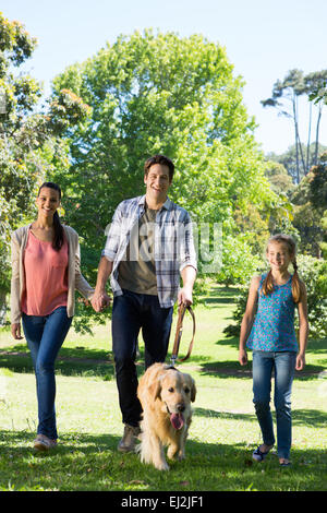 Happy Family walking leur chien dans le parc Banque D'Images