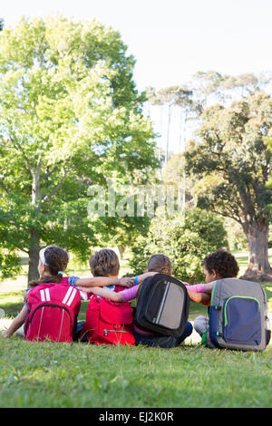 School children sitting on grass Banque D'Images