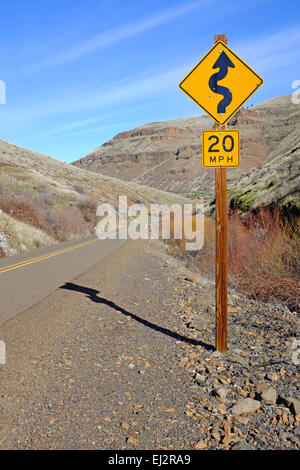 Un panneau d'avertissement sur une route de montagne sinueuse, dans le centre nord de l'oregon. Banque D'Images