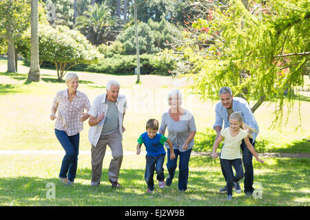 Famille heureuse courir dans le parc Banque D'Images