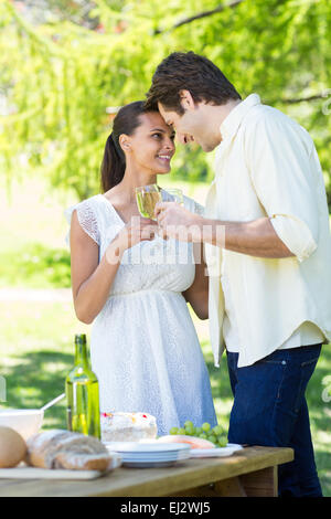 Cute couple toasting in the park Banque D'Images