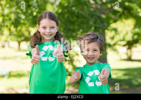 Frères et sœurs heureux en vert avec Thumbs up Banque D'Images