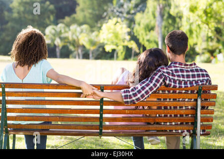 Lonely Woman sitting with couple in park Banque D'Images