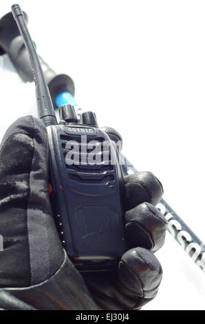 Hand in glove holding walkie talkie radio. Arrière-plan de la neige Banque D'Images