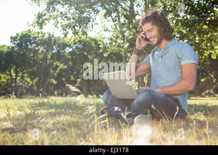 Young man using laptop in the park Banque D'Images