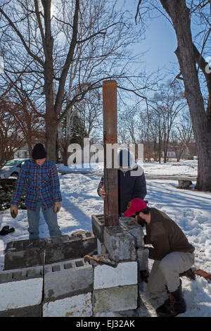 Detroit, Michigan - les agriculteurs urbains construction d'un poêle à bois extérieur temporaire pour faire bouillir la sève des arbres d'érable à sucre pour faire du sirop. Banque D'Images