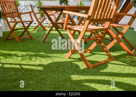 Table et chaises en bois sur l'herbe verte Banque D'Images