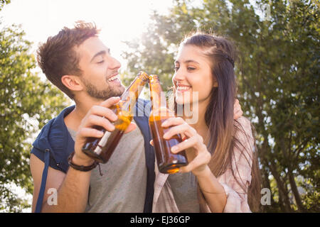 Happy friends dans le parc ayant beers Banque D'Images