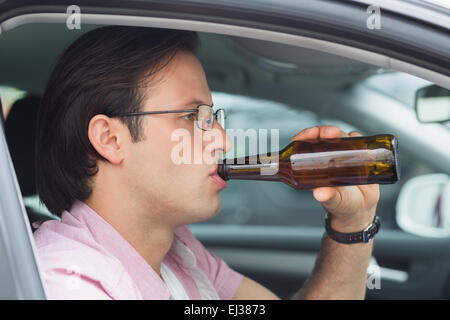 Man drinking beer en conduisant Banque D'Images