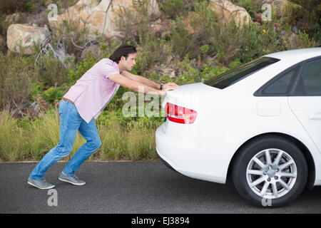 Man pushing voiture après une panne de voiture Banque D'Images