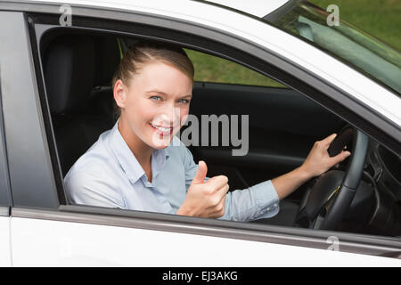 Smiling businesswoman sitting in drivers seat Banque D'Images