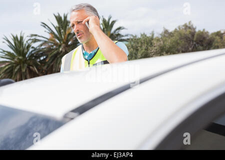 Unsmiling man appelant à l'aide après avoir briser Banque D'Images