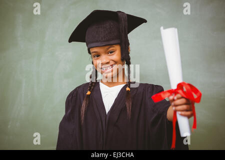 Little girl in graduation robe holding diploma Banque D'Images