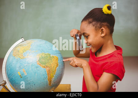 Little girl looking at globe par loupe Banque D'Images