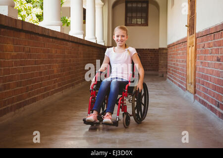 Girl sitting in wheelchair in school corridor Banque D'Images