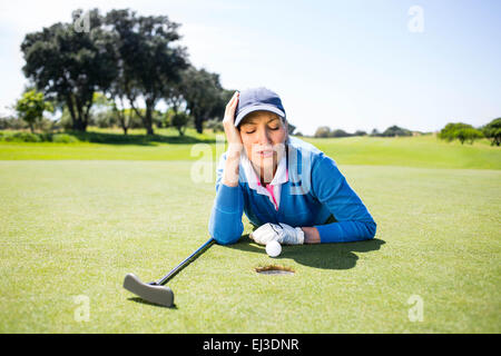 Golfeuse regardant sa balle sur un green Banque D'Images