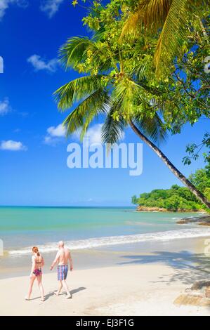 Les touristes à pied le long de la plage en complexe exotique à Sainte-Lucie, Caraïbes Banque D'Images