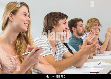 Les élèves en classe les mains dans les mains Banque D'Images