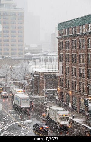 New York City, New York State, USA, vendredi 20 mars 2015 ; la neige le premier jour du printemps apporte un chasse-neige pour rejoindre le jersey lié le trafic de banlieue sur 11th Avenue & dépose une croûte de blanc sur l'immeuble en briques anciennes tènements fire s'échappe alors qu'une voiture de patrouille s'arrête à l'angle deli pour prendre encore un café chaud dans le quartier Hell's Kitchen Crédit : Dorothy Alexander/Alamy Live News Banque D'Images