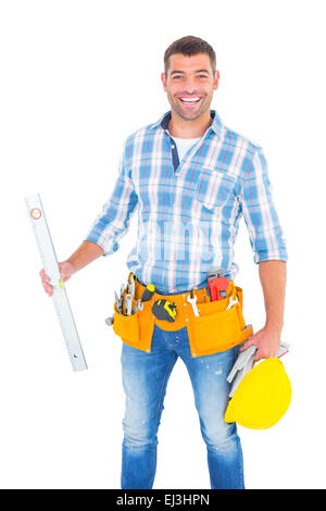 Portrait of smiling manual worker holding spirit level Banque D'Images