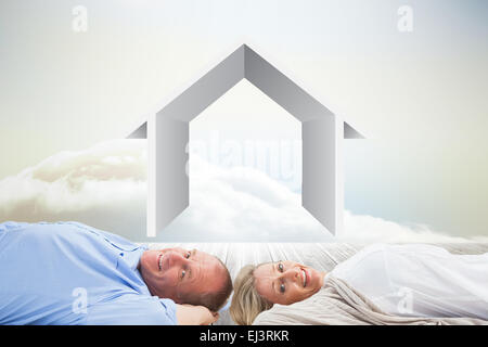 Image composite de mature couple lying and smiling Banque D'Images