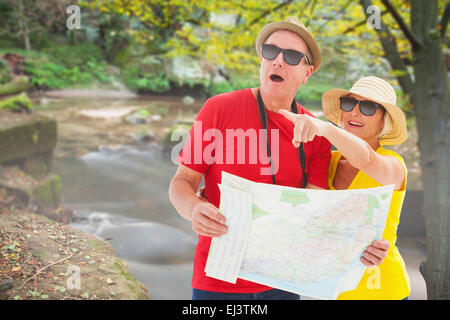 Image composite de happy tourist couple en utilisant la carte Banque D'Images