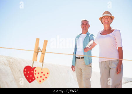 Image composite de happy senior couple walking on the pier Banque D'Images
