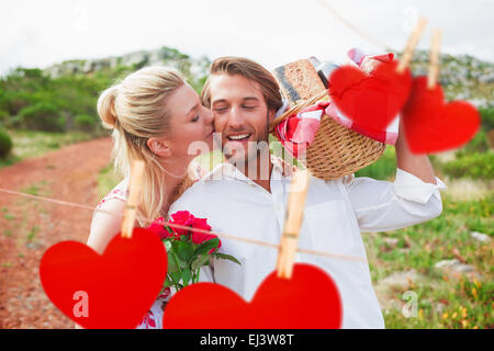 Image composite de cute couple passe pour un pique-nique avec woman kissing boyfriends joue Banque D'Images