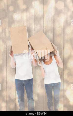 Composite image of mature couple with boxes sur leur tête Banque D'Images