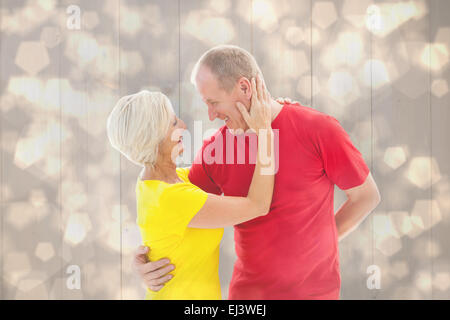 Composite image of mature couple hugging and smiling Banque D'Images