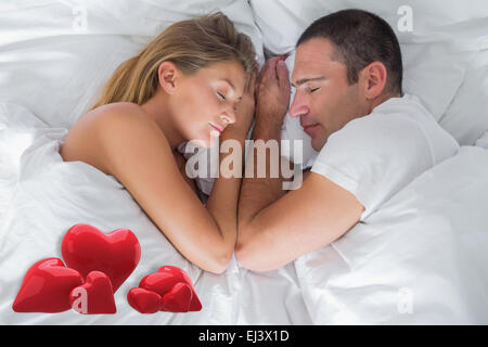 Image composite de cute couple lying asleep in bed Banque D'Images
