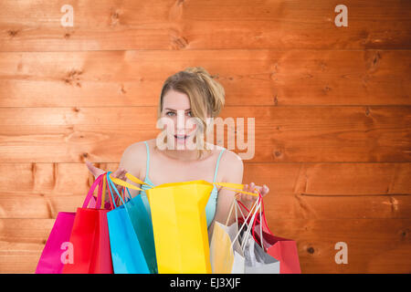 Image composite de excited woman looking at camera avec de nombreux sacs de magasinage Banque D'Images