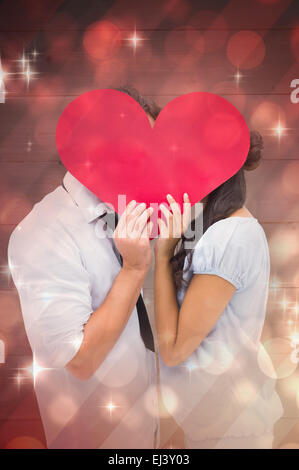 Image composite du couple couvrant leur baiser avec un coeur Banque D'Images