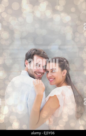 Image composite de l'attractive young couple smiling at camera Banque D'Images