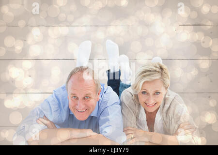 Composite image of mature couple lying and smiling Banque D'Images