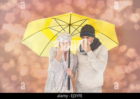 Image composite de couple in winter fashion éternuements under umbrella Banque D'Images