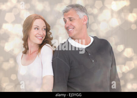 Image composite de casual couple smiling at each other Banque D'Images