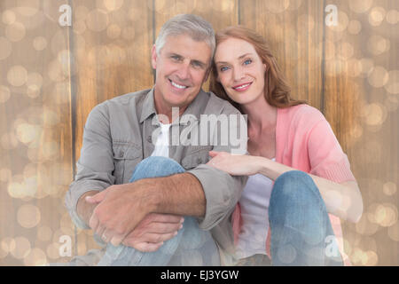 Image composite de casual couple sitting and smiling Banque D'Images