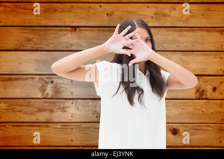 Image composite de peur brunette couvrant son visage Banque D'Images