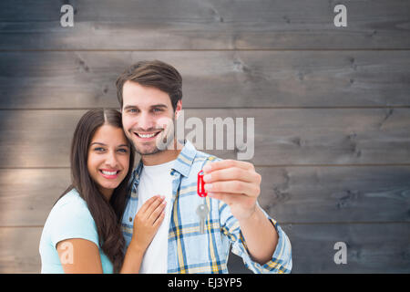 Image composite de happy young couple holding nouvelle clé de la maison Banque D'Images