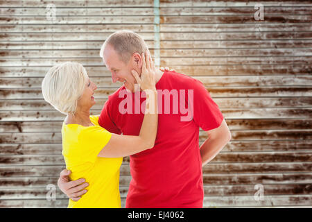 Composite image of mature couple hugging and smiling Banque D'Images