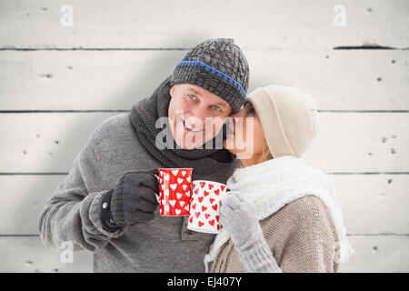 Image composite de mature woman in winter clothes holding mugs Banque D'Images