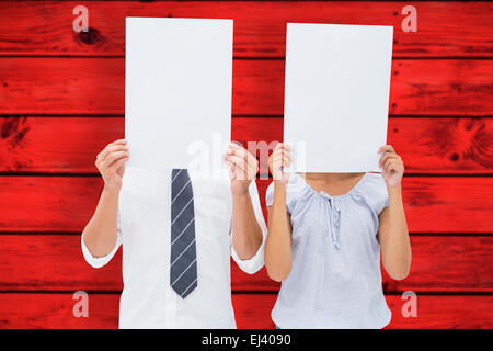 Image composite du couple holding paper sur leurs visages Banque D'Images