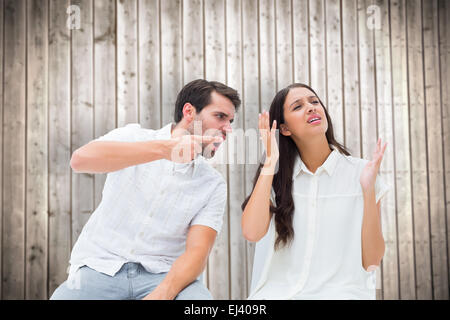 Image composite de couple assis sur des chaises en faisant valoir Banque D'Images